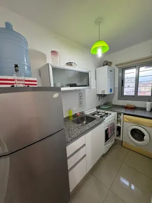 a kitchen with a sink and a stove top oven at Myng Departamento en el centro de Carlos Paz in Villa Carlos Paz