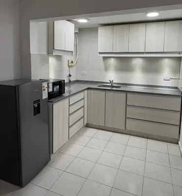a kitchen with a refrigerator and a sink at Departamento PA in Villa Carlos Paz