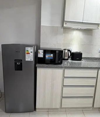 a kitchen with a microwave and a refrigerator at Departamento PA in Villa Carlos Paz