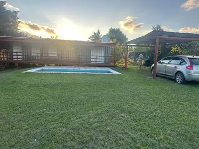 a yard with a car parked next to a house at Cabaña Habibi in Potrero de Garay