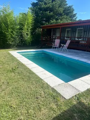 a swimming pool with two chairs in a yard at Cabaña Habibi in Potrero de Garay