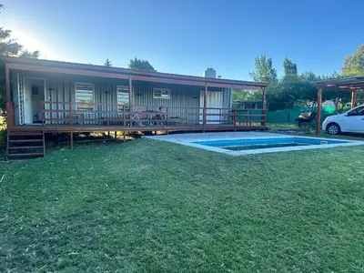 a house with a deck and a swimming pool at Cabaña Habibi in Potrero de Garay