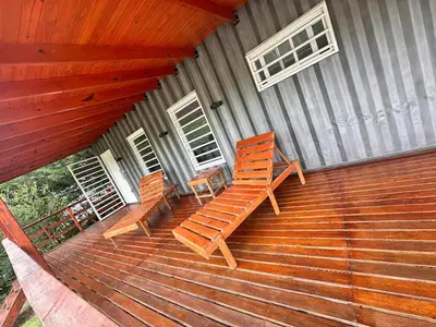 two wooden chairs sitting on a porch of a house at Cabaña Habibi in Potrero de Garay