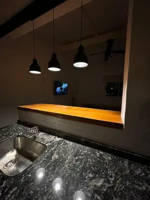 a kitchen with a counter with a sink and lights at Disfruta casa de bosque a metros de AV San martin y minutos del lago in Villa Carlos Paz