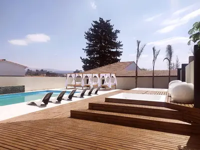 a group of chairs sitting on a deck next to a swimming pool at Astoria Hotel in Villa Carlos Paz