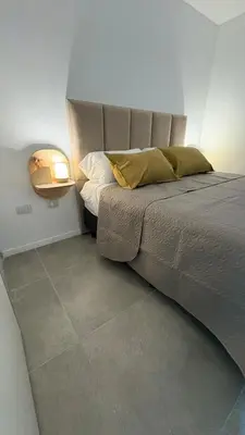 a bedroom with a bed and a lamp on the floor at New Modern Apartment Ciudad Gamma Cordoba Luxury in Cordoba