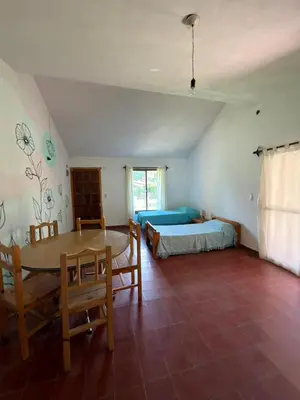 a bedroom with a table and a bed and a table and chairs at El Amanecer in Mina Clavero