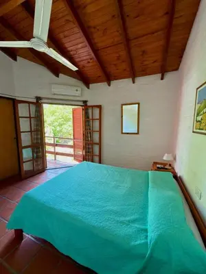 a bedroom with a large blue bed in a room at El Amanecer in Mina Clavero