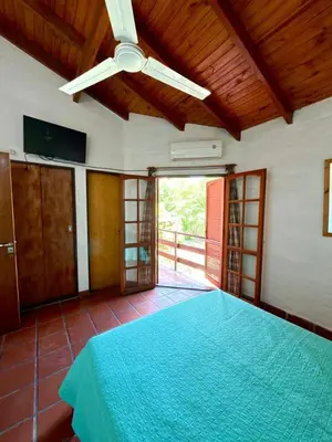 a bedroom with a large bed with a ceiling fan at El Amanecer in Mina Clavero