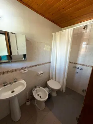 a bathroom with a sink and a toilet and a mirror at El Amanecer in Mina Clavero