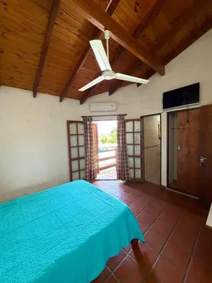 a bedroom with a blue bed and a ceiling fan at El Amanecer in Mina Clavero