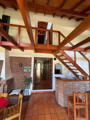 a room with a brick fireplace and a wooden ceiling at El Amanecer in Mina Clavero