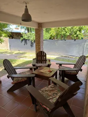 a patio with two chairs and a wooden table and chairs at El Amanecer in Mina Clavero