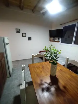 a dining room with a wooden table with a plant on it at La Eterna in Villa del Dique