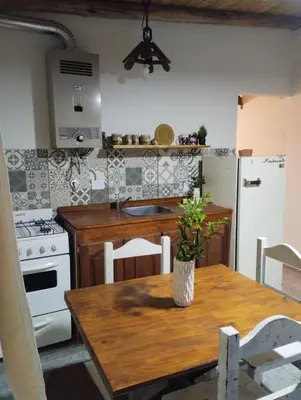a kitchen with a wooden table and a refrigerator at La Eterna in Villa del Dique