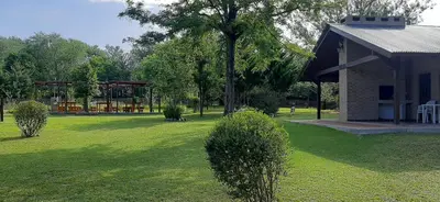 a yard with a house and a pavilion with a park at TARDES De MONTAÑA in Santa Rosa de Calamuchita
