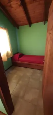 a room with a red couch in a green wall at TARDES De MONTAÑA in Santa Rosa de Calamuchita