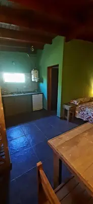 a kitchen with green walls and a table in a room at TARDES De MONTAÑA in Santa Rosa de Calamuchita