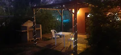 a table and a chair on a patio at night at TARDES De MONTAÑA in Santa Rosa de Calamuchita