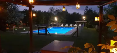 a swimming pool in a backyard at night at TARDES De MONTAÑA in Santa Rosa de Calamuchita