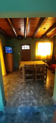 a large room with a wooden table and a window at TARDES De MONTAÑA in Santa Rosa de Calamuchita
