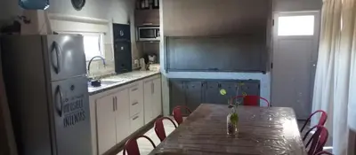 a kitchen with a table with chairs and a refrigerator at Biale Masse Casa de Montaña in Bialet Massé