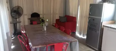 a dining room table with red chairs and a red couch at Biale Masse Casa de Montaña in Bialet Massé
