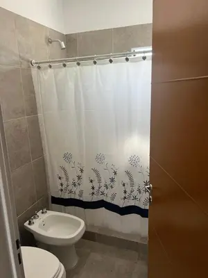 a bathroom with a toilet and a shower curtain at Biale Masse Casa de Montaña in Bialet Massé