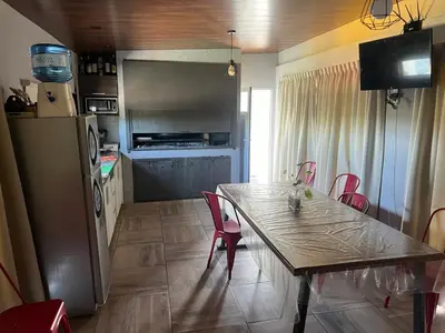 a kitchen with a table and chairs and a refrigerator at Biale Masse Casa de Montaña in Bialet Massé