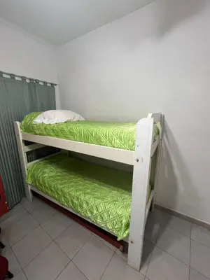 two bunk beds in a room with green sheets at La casa del varón in Mina Clavero