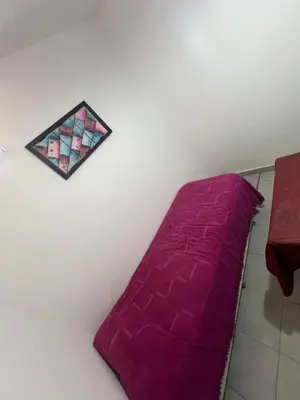 a purple bed in a room with a table at La casa del varón in Mina Clavero