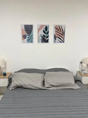 a bedroom with a bed with four pictures on the wall at Monoambiente centro Carlos Paz in Villa Carlos Paz