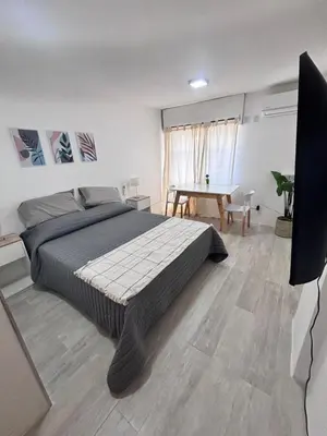 a bedroom with a large bed and a table at Monoambiente centro Carlos Paz in Villa Carlos Paz