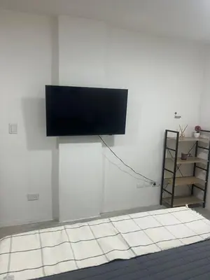 a flat screen tv hanging on a white wall at Monoambiente centro Carlos Paz in Villa Carlos Paz