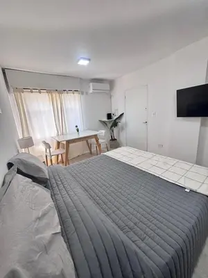 a bedroom with a large bed and a table at Monoambiente centro Carlos Paz in Villa Carlos Paz