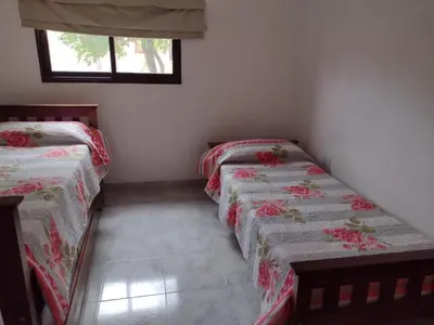 two twin beds in a room with a window at Portal del rio mina clavero in Mina Clavero
