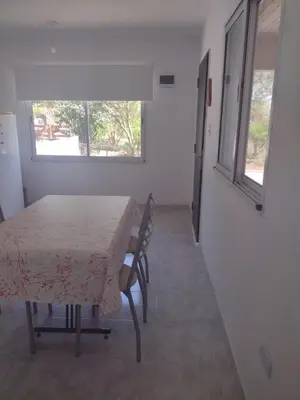 a room with a table and chairs and a window at Portal del rio mina clavero in Mina Clavero