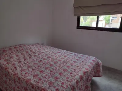 a bedroom with a bed with a red flowered blanket at Portal del rio mina clavero in Mina Clavero