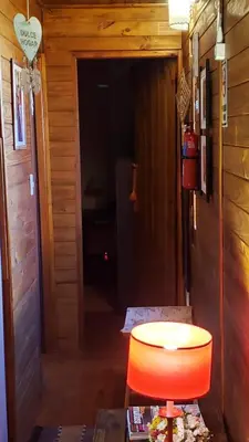 a room with a table and a orange chair at Cabaña Alma in Villa Carlos Paz