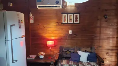 a living room with a refrigerator and a table and a refrigerator at Cabaña Alma in Villa Carlos Paz
