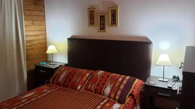 a hotel room with a bed and two night stands at Cabaña Alma in Villa Carlos Paz
