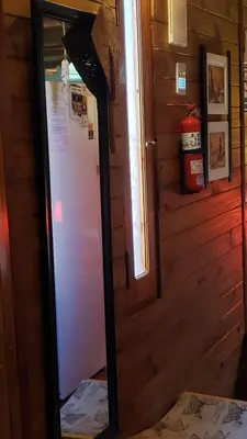 a mirror in front of a refrigerator in a room at Cabaña Alma in Villa Carlos Paz