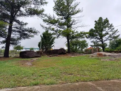 a field with some trees and rocks and trees at Hermosa propiedad para 8 y 10 personas piscina quincho gran parque in Cavalango