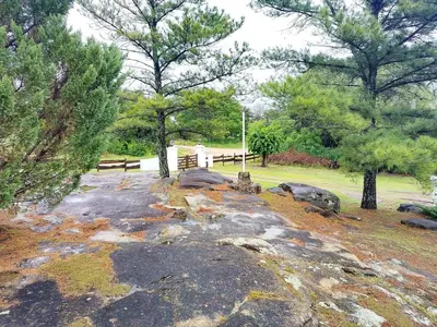 a park with a bench and some trees and rocks at Hermosa propiedad para 8 y 10 personas piscina quincho gran parque in Cavalango