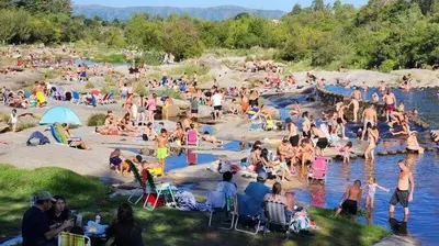 a large group of people sitting on the beach at Hermosa propiedad para 8 y 10 personas piscina quincho gran parque in Cavalango