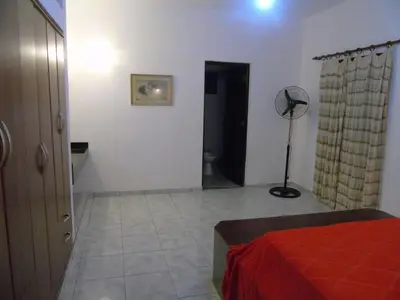 a bedroom with a bed and a floor fan at Hermosa propiedad para 8 y 10 personas piscina quincho gran parque in Cavalango