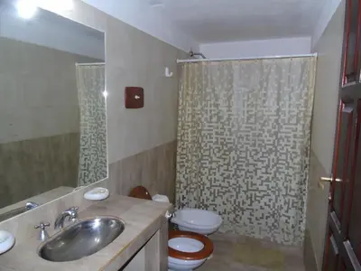 a bathroom with a sink and a toilet and a shower at Hermosa propiedad para 8 y 10 personas piscina quincho gran parque in Cavalango