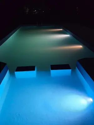 a swimming pool with blue lighting in a room at Hermosa propiedad para 8 y 10 personas piscina quincho gran parque in Cavalango