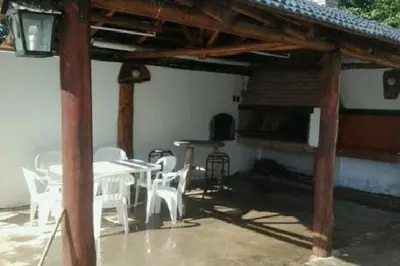 a patio with white chairs and a table and a fireplace at Hermosa propiedad para 8 y 10 personas piscina quincho gran parque in Cavalango