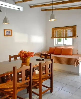 a dining room with a table and a couch at Cabañas Costa Vergel in Los Reartes